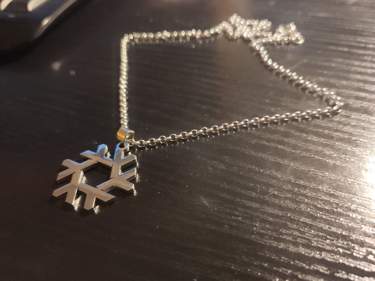 A necklace shaped like the Nix logo